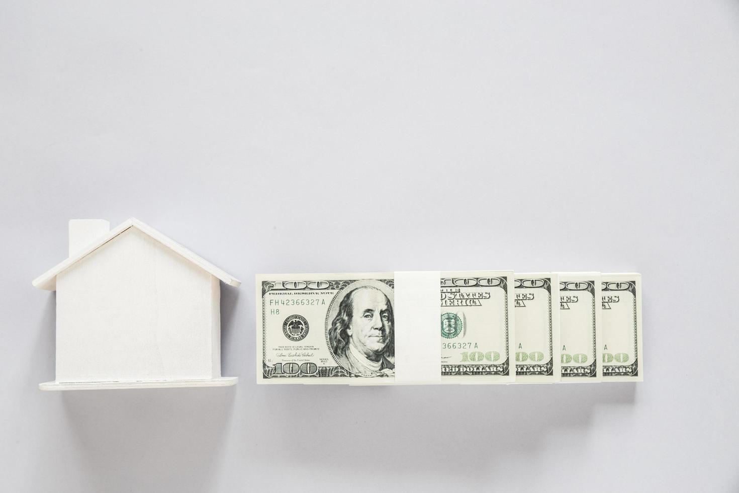 vista superior da nota de dólar com casa de madeira foto