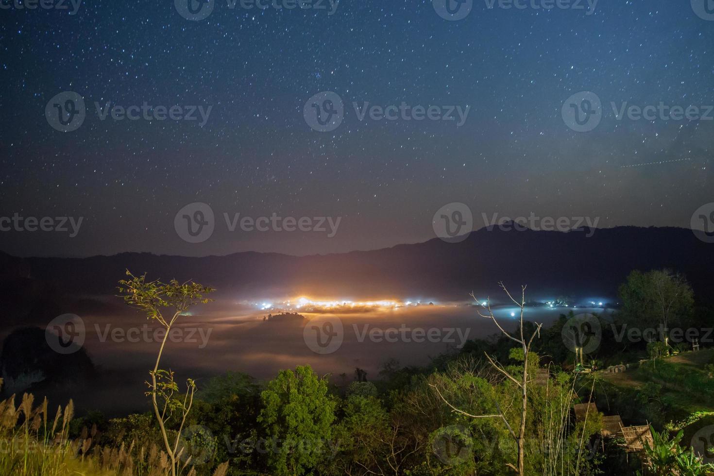 vista de uma cidade e da Via Láctea foto