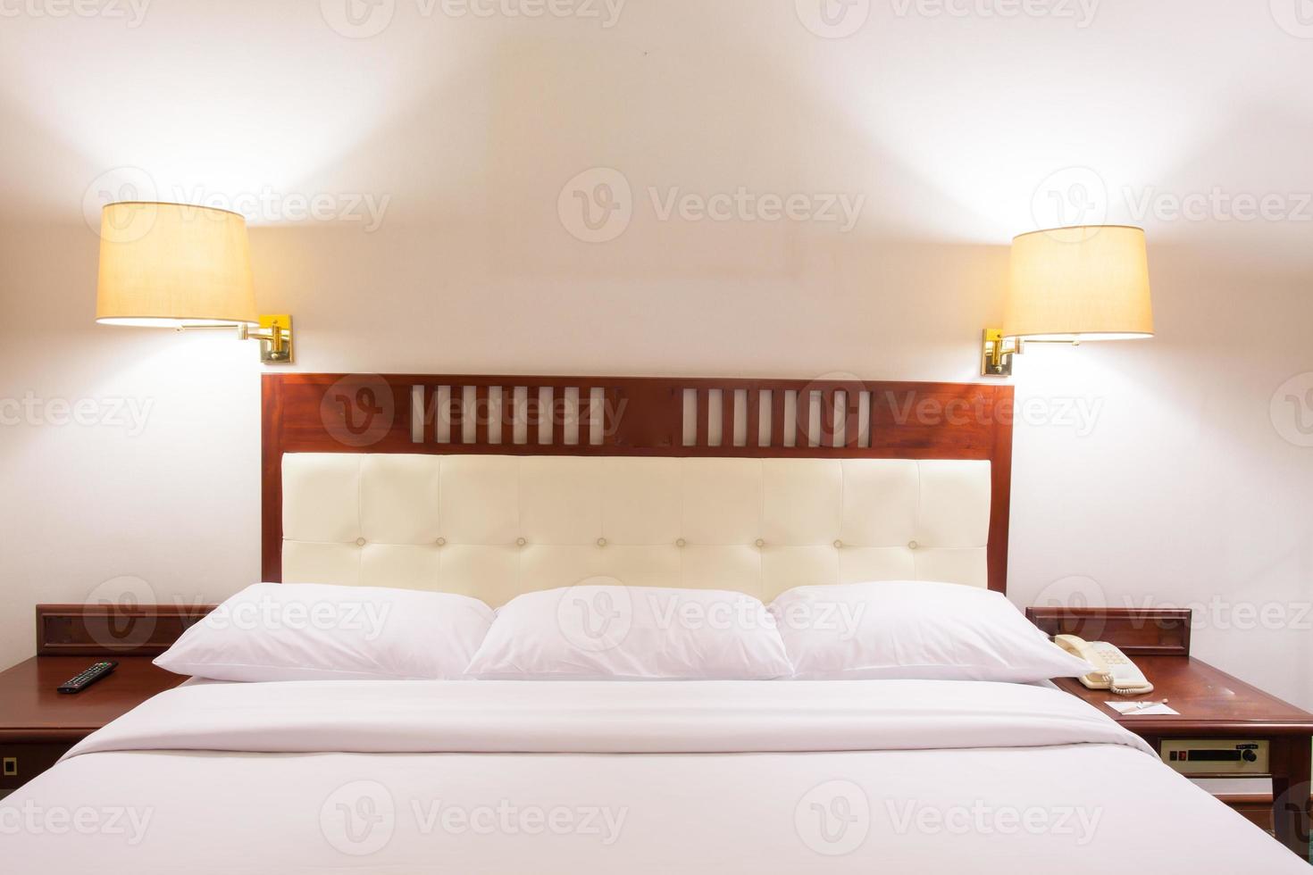 cama de hotel com lâmpadas de cabeceira foto