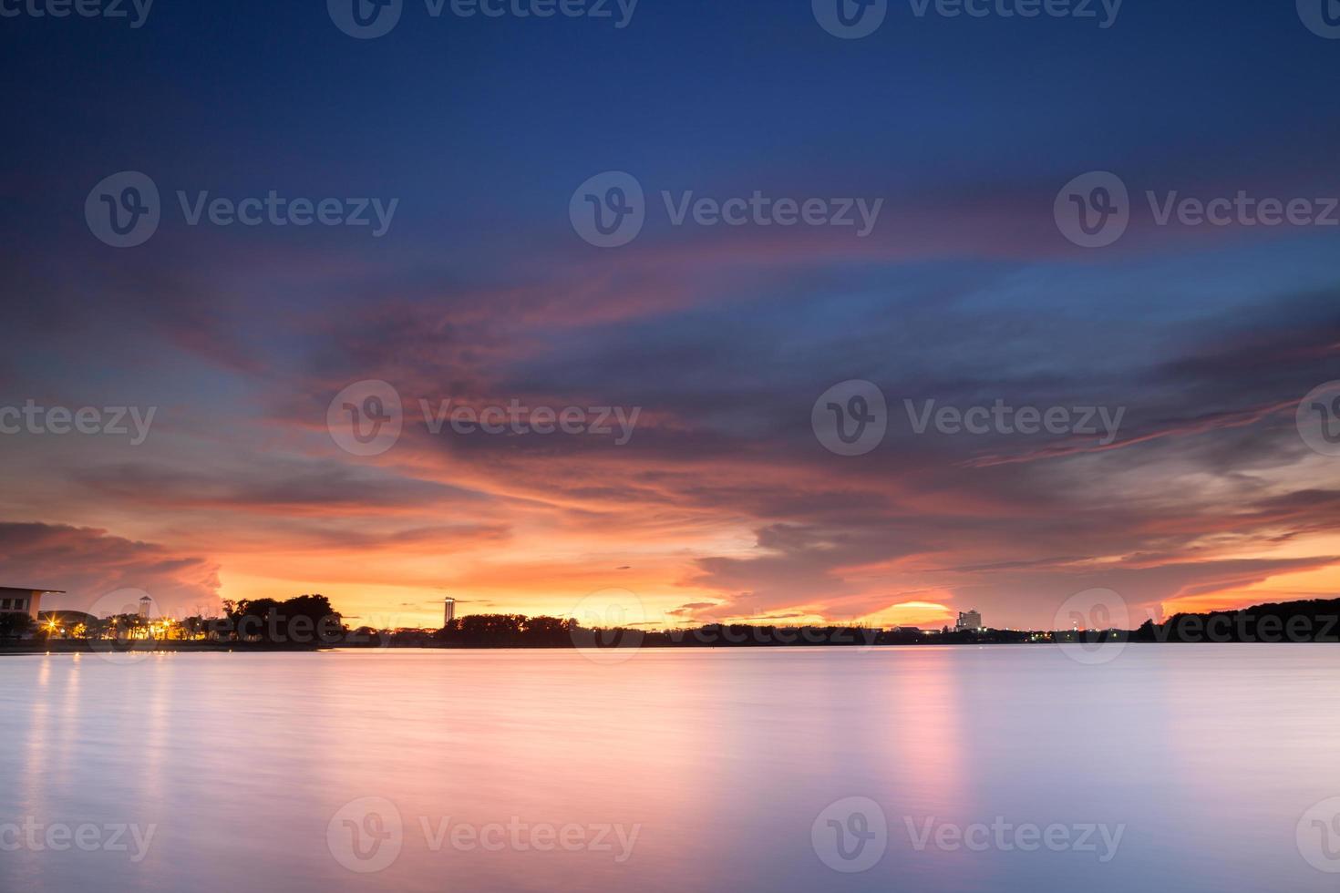 céu dramático pôr do sol sobre a água foto