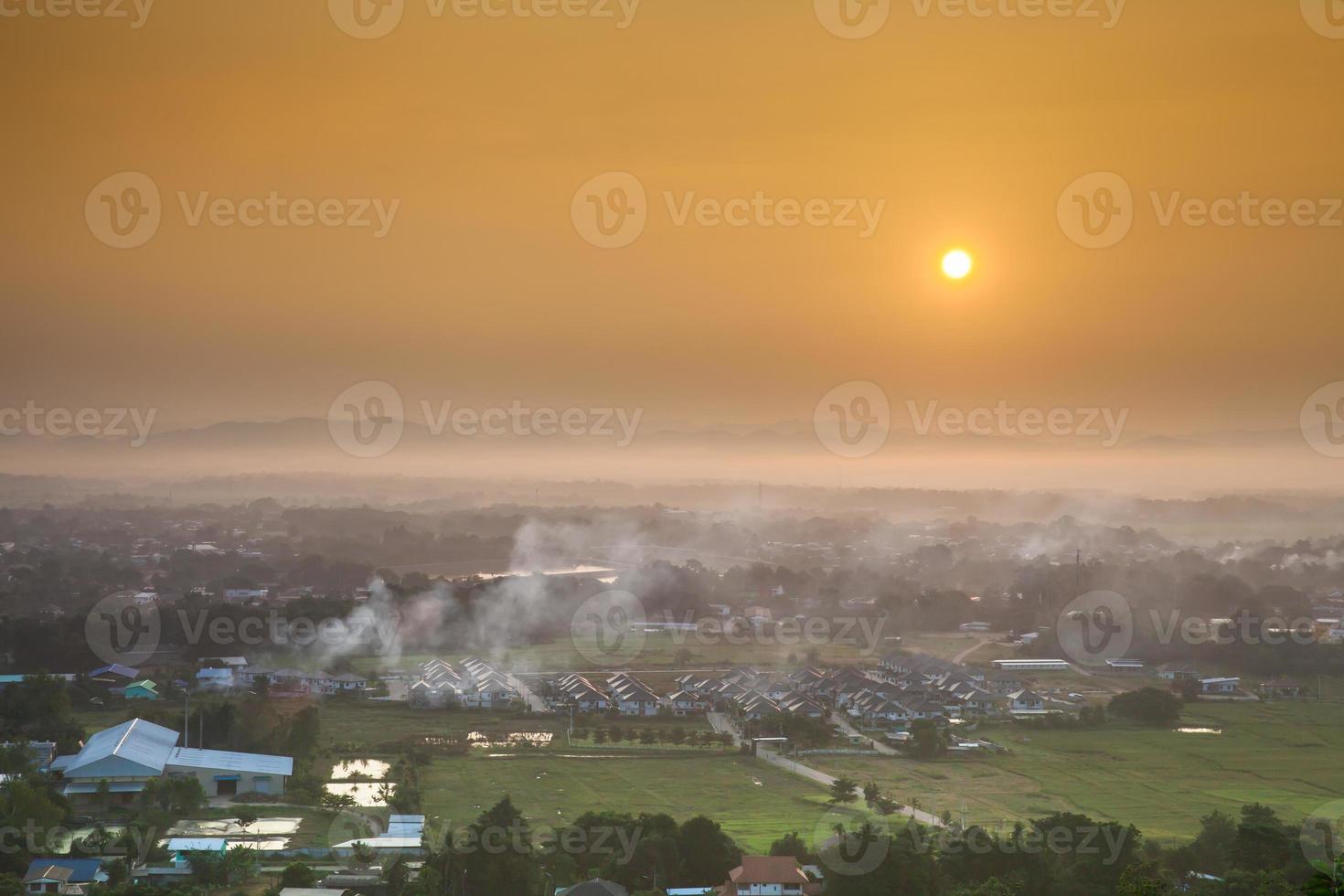 nascer do sol nebuloso sobre uma cidade foto