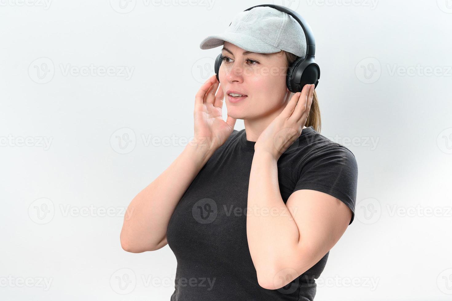 retrato do uma menina em uma branco fundo com sem fio fones de ouvido e uma chapéu em dela cabeça. foto