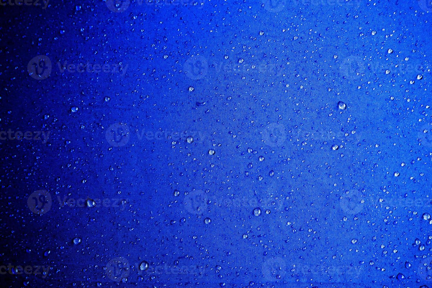 gotas de água sobre o tecido azul gotas de água sobre fundo azul foto