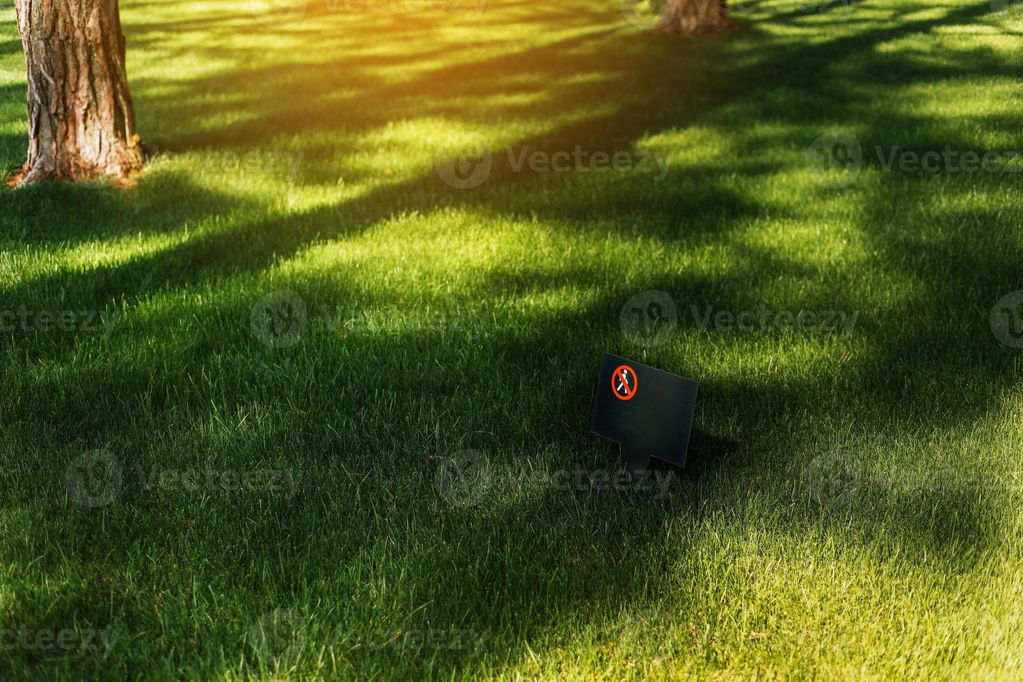 a proibitivo placa Faz não andar a gramado contra a verde gramado dentro suave luz solar. isto é proibido para andar em a grama. placa proibindo caminhando em a grama. Faz não degrau em grama. Lugar, colocar para texto foto