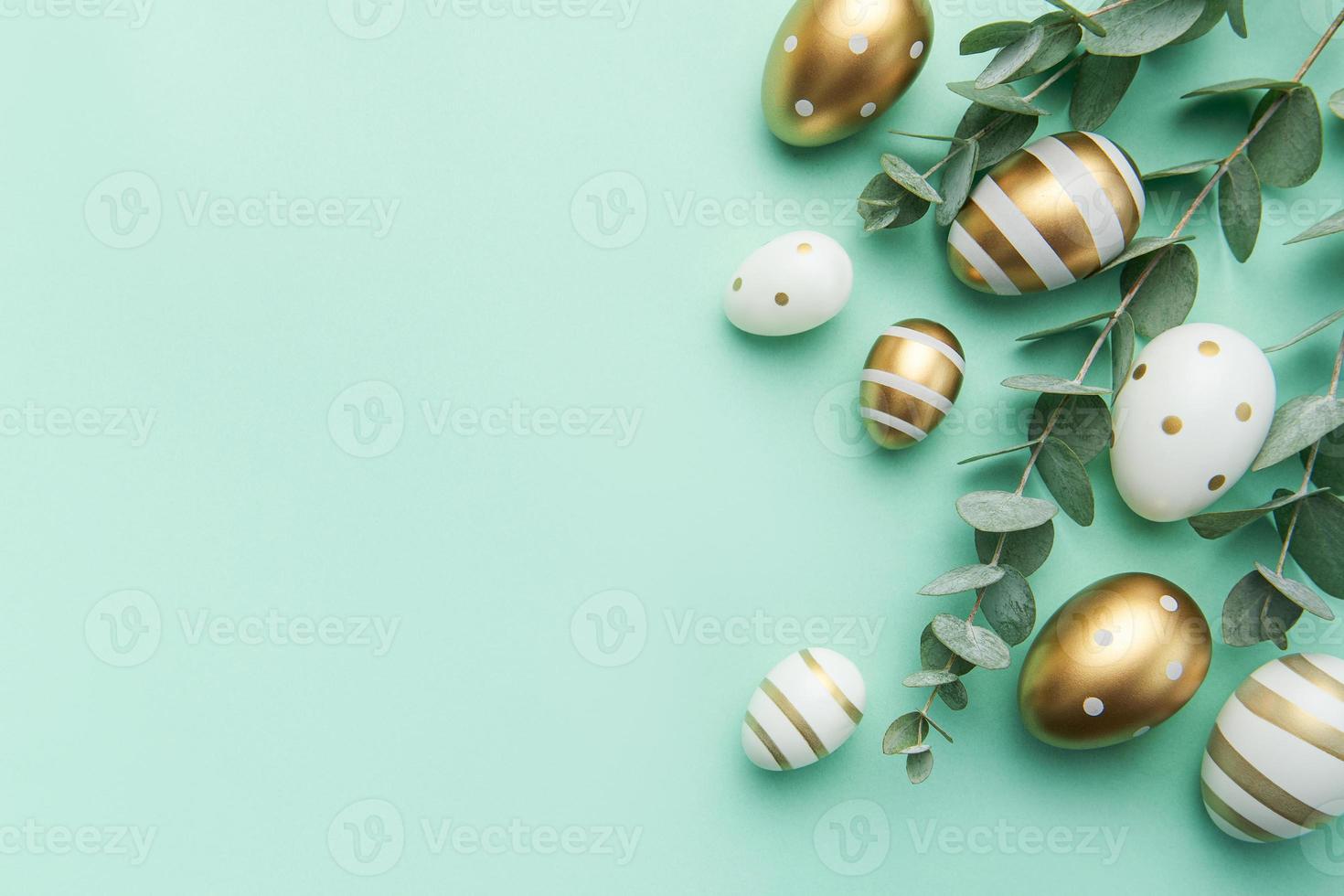 Páscoa ovos pintado dentro ouro e eucalipto galhos em uma suave verde fundo. foto