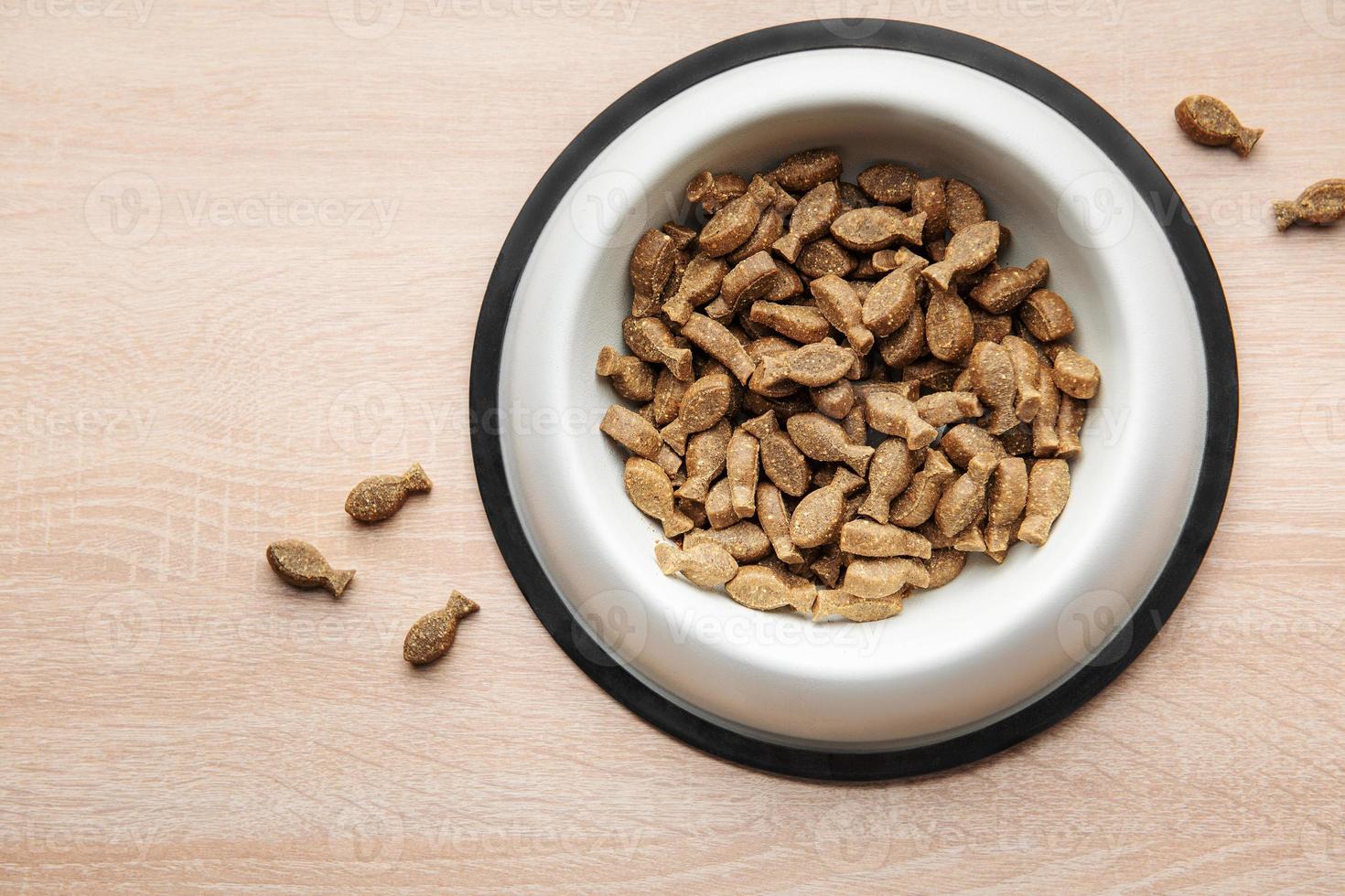 uma tigela de comida de cachorro em um piso de madeira. foto