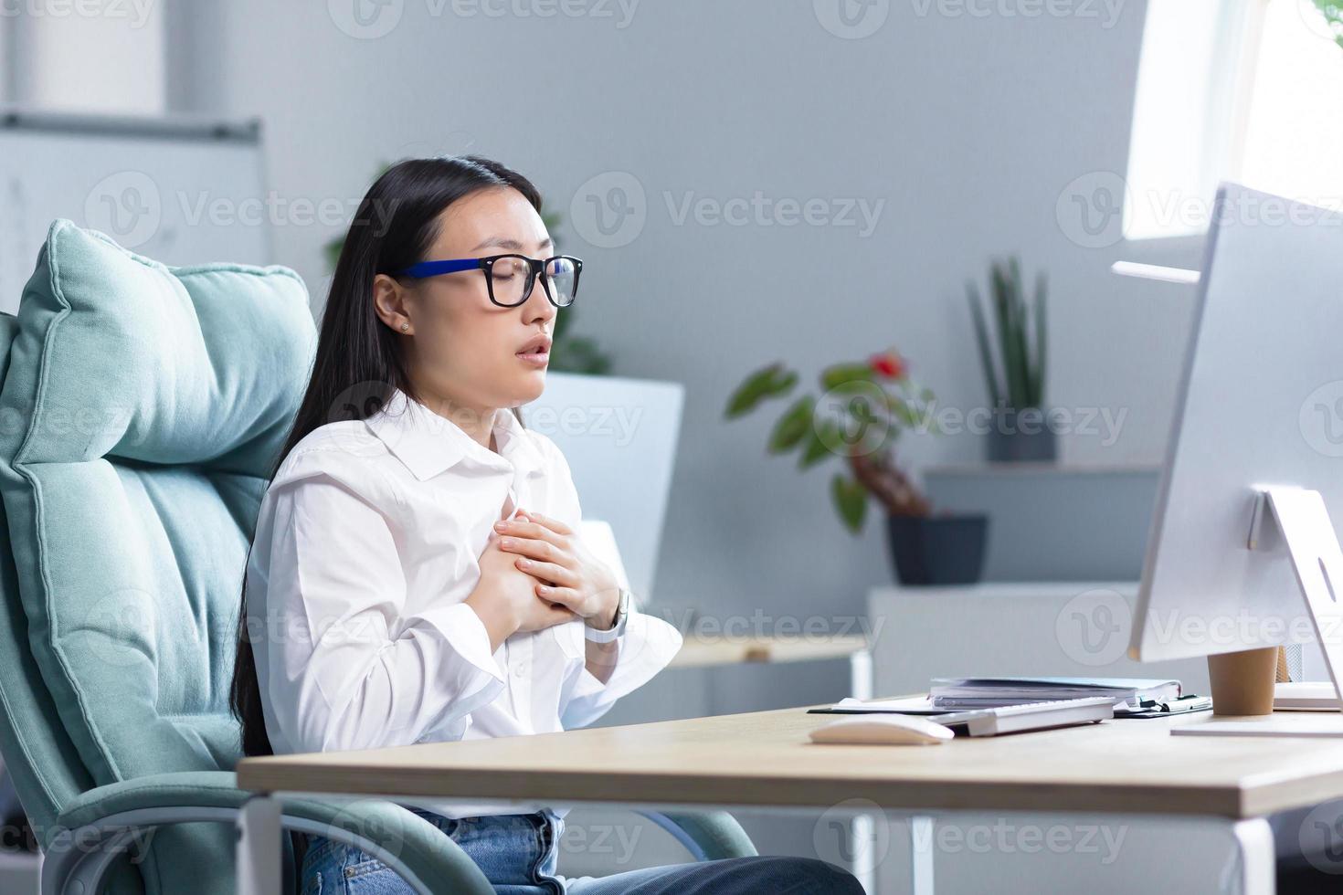 jovem lindo ásia fêmea escritório trabalhador cansado e doente tendo forte peito dor foto