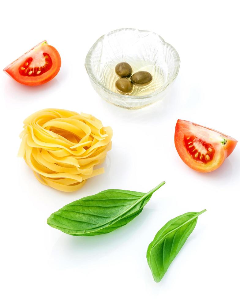 fettuccine com isolado de tomate e manjericão doce em fundo branco. foto