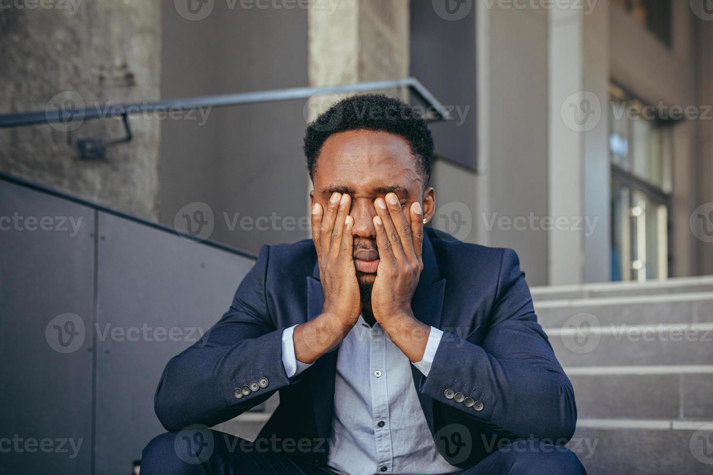 empresário africano sentado frustrado nas escadas deprimido pelos resultados de seu trabalho foto