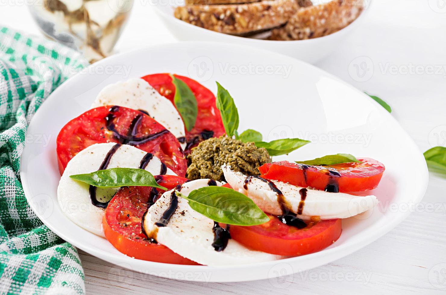 tradicional italiano caprese salada com mussarela, tomate, manjericão e balsâmico vinagre foto