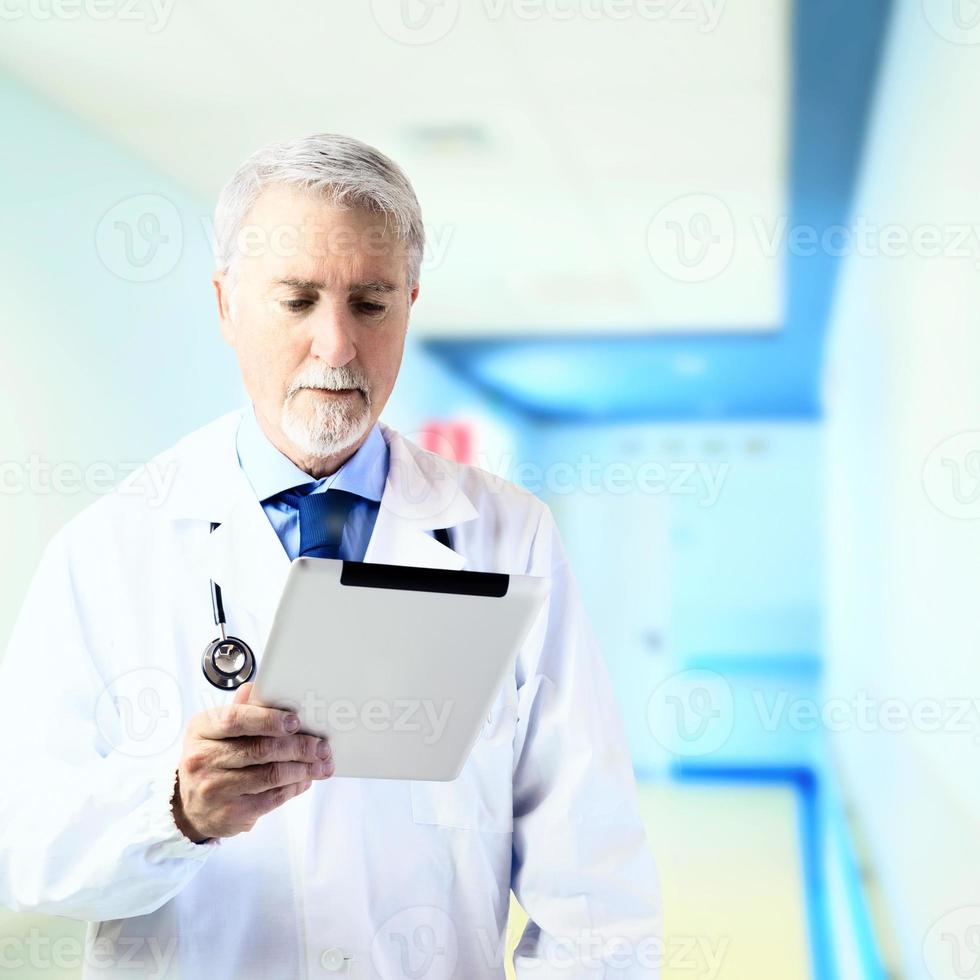 médico no corredor do hospital com um tablet foto