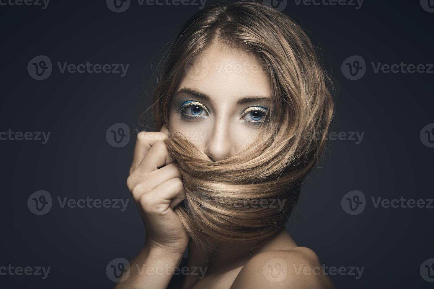 retrato da beleza de uma jovem mulher sexy contra um fundo azul escuro foto