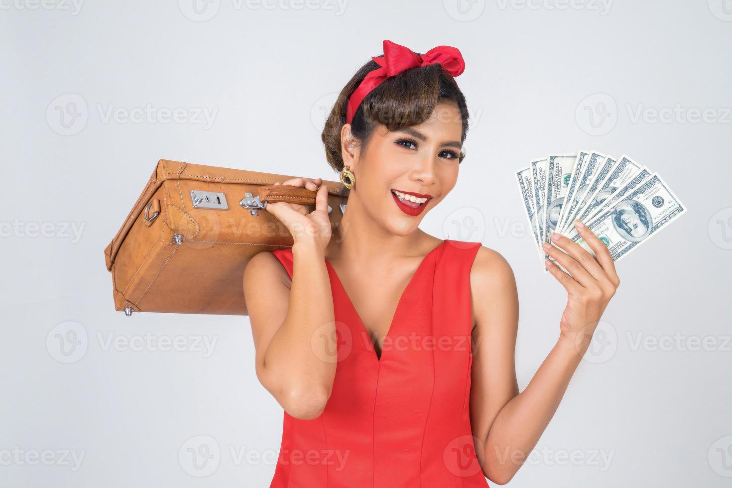 mulher na moda retrô guarda bagagem e dinheiro para viajar foto