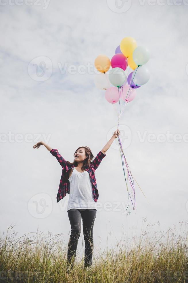 bela jovem hippie segurando balões coloridos ao ar livre foto