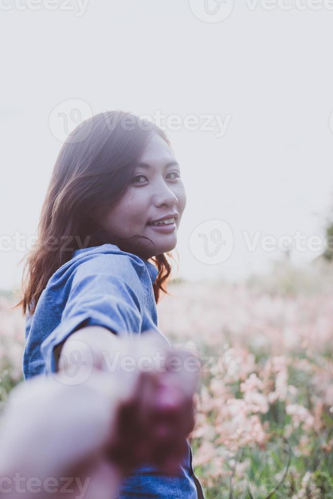 mulher jovem hippie feliz puxando a mão do cara foto