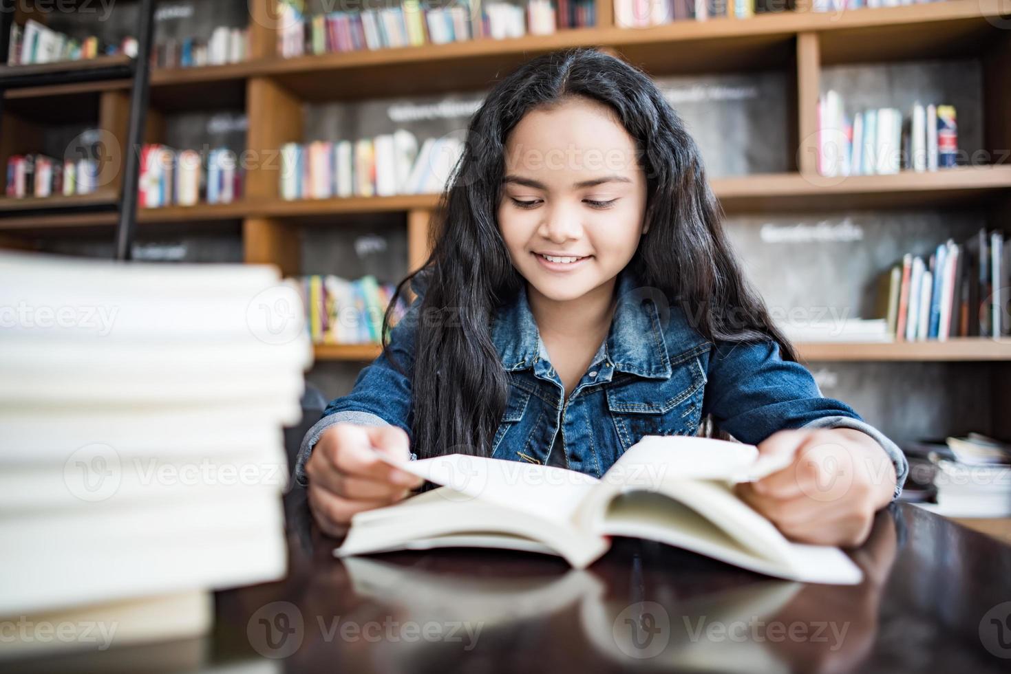 jovem lendo um livro sentada dentro de casa em um café urbano foto