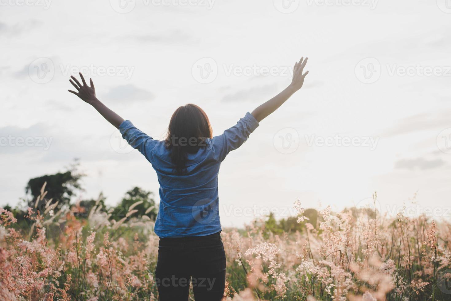 jovem mulher feliz curtindo o pôr do sol foto