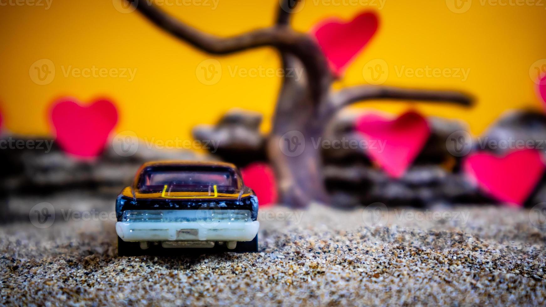 minahasa, indonésia, dezembro de 2022, carro de brinquedo com fundo laranja gradiente e coração foto