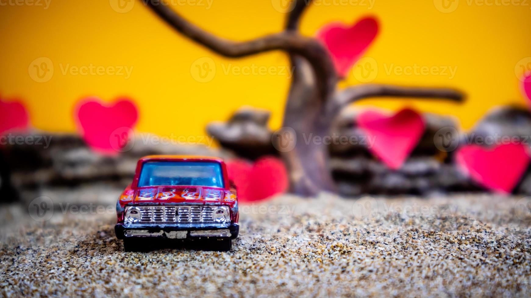 minahasa, indonésia, dezembro de 2022, carro de brinquedo com fundo laranja gradiente e coração foto