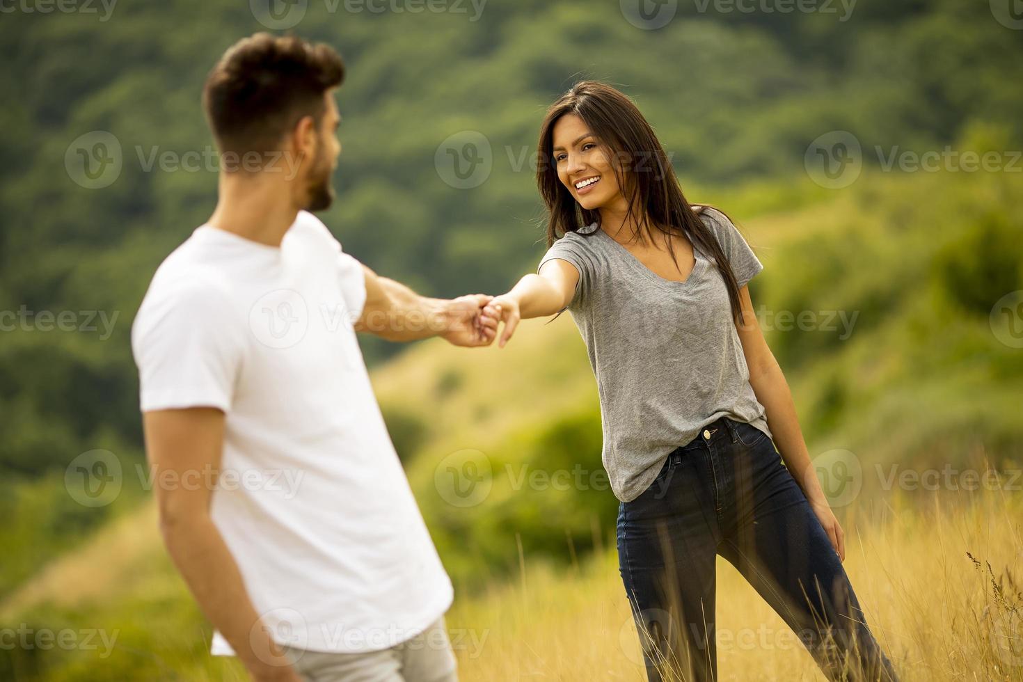 jovem casal apaixonado caminhando pela grama foto