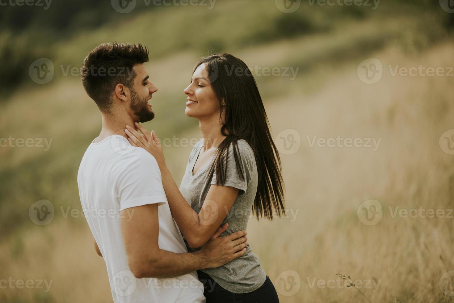 jovem casal apaixonado no campo de grama foto