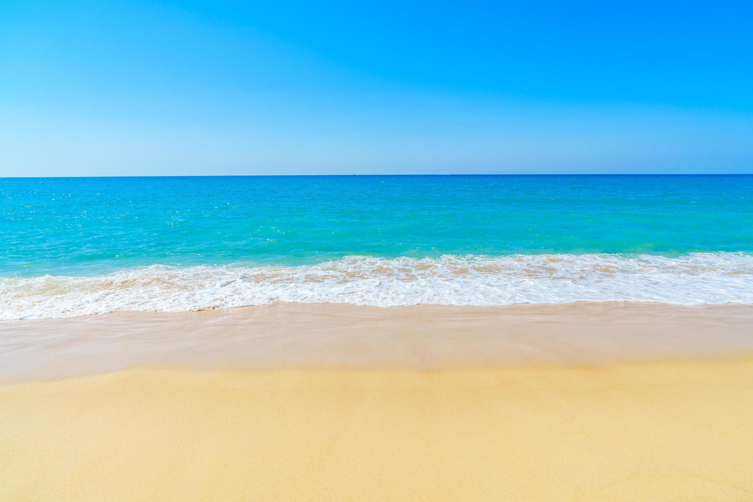 bela praia de areia e mar foto