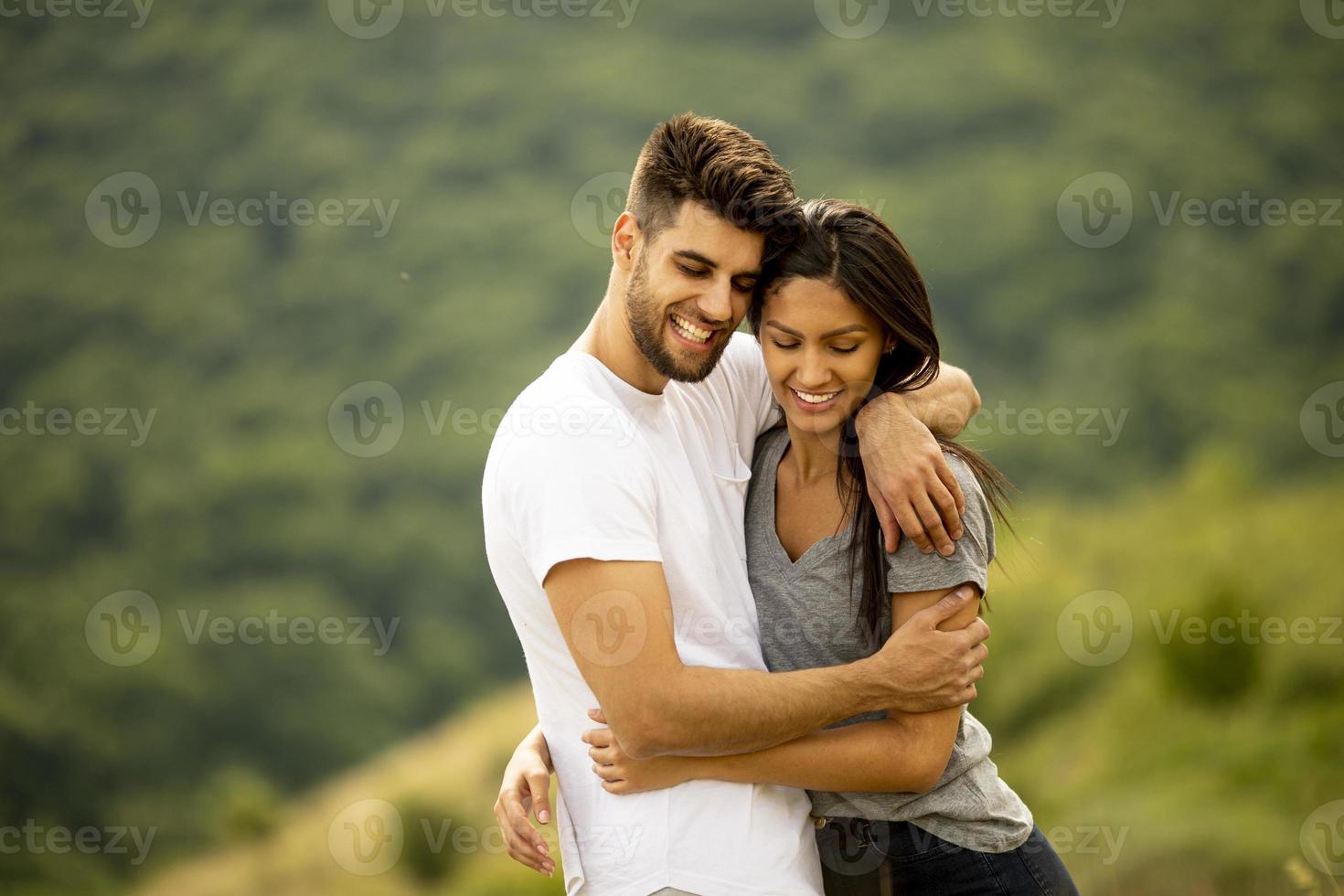 jovem casal apaixonado no campo de grama foto