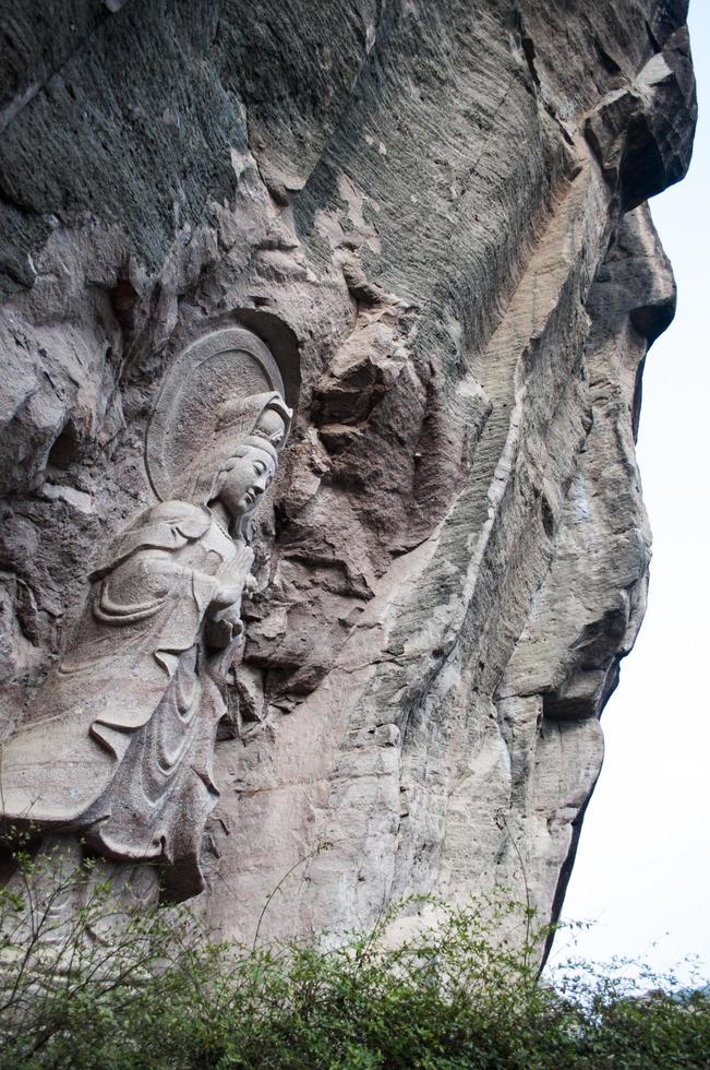 estátua do Avalokitesvara esculpido dentro uma grande Rocha foto