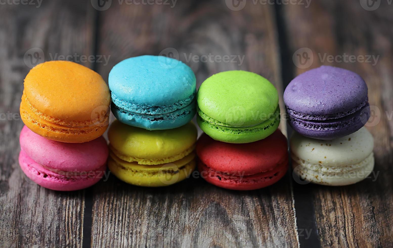 Macarons coloridos na mesa de madeira foto