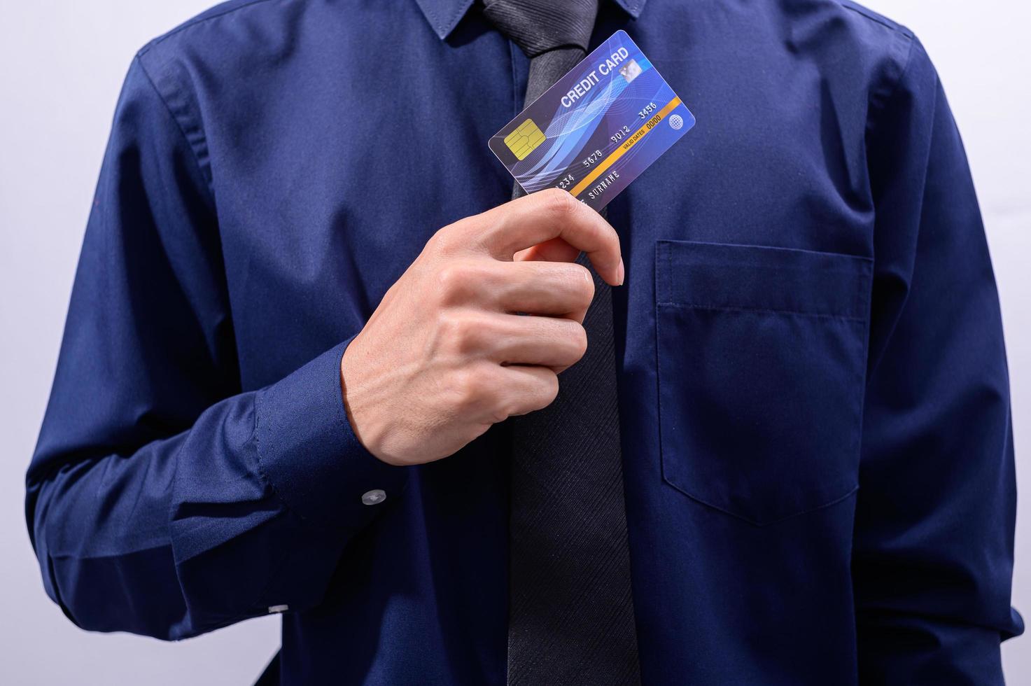 empresário segurando um cartão de crédito foto