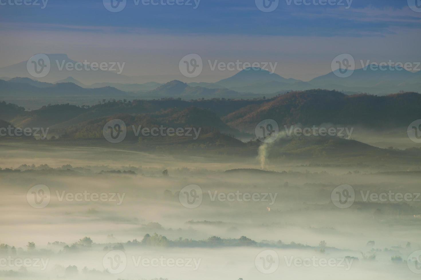 topos de montanhas com nevoeiro ao nascer do sol foto