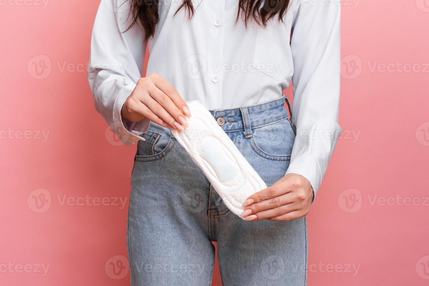 estúdio tiro do uma jovem menina com menstrual preenchimento dentro dela mãos. a conceito do feminino higiene. foto