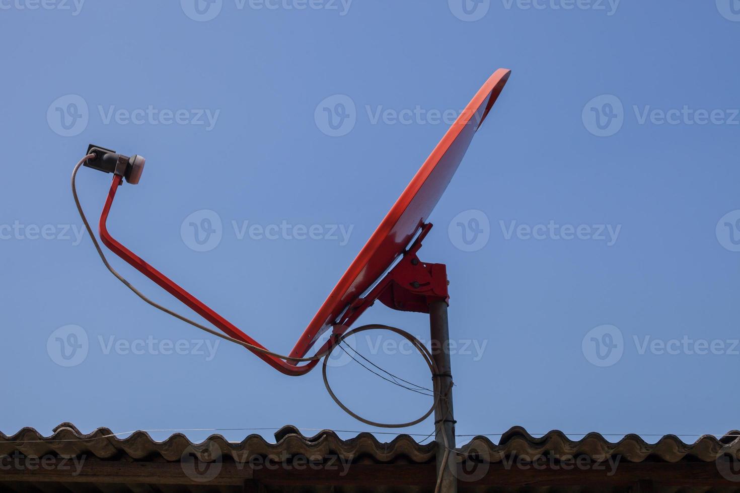 antena parabólica vermelha em um telhado foto