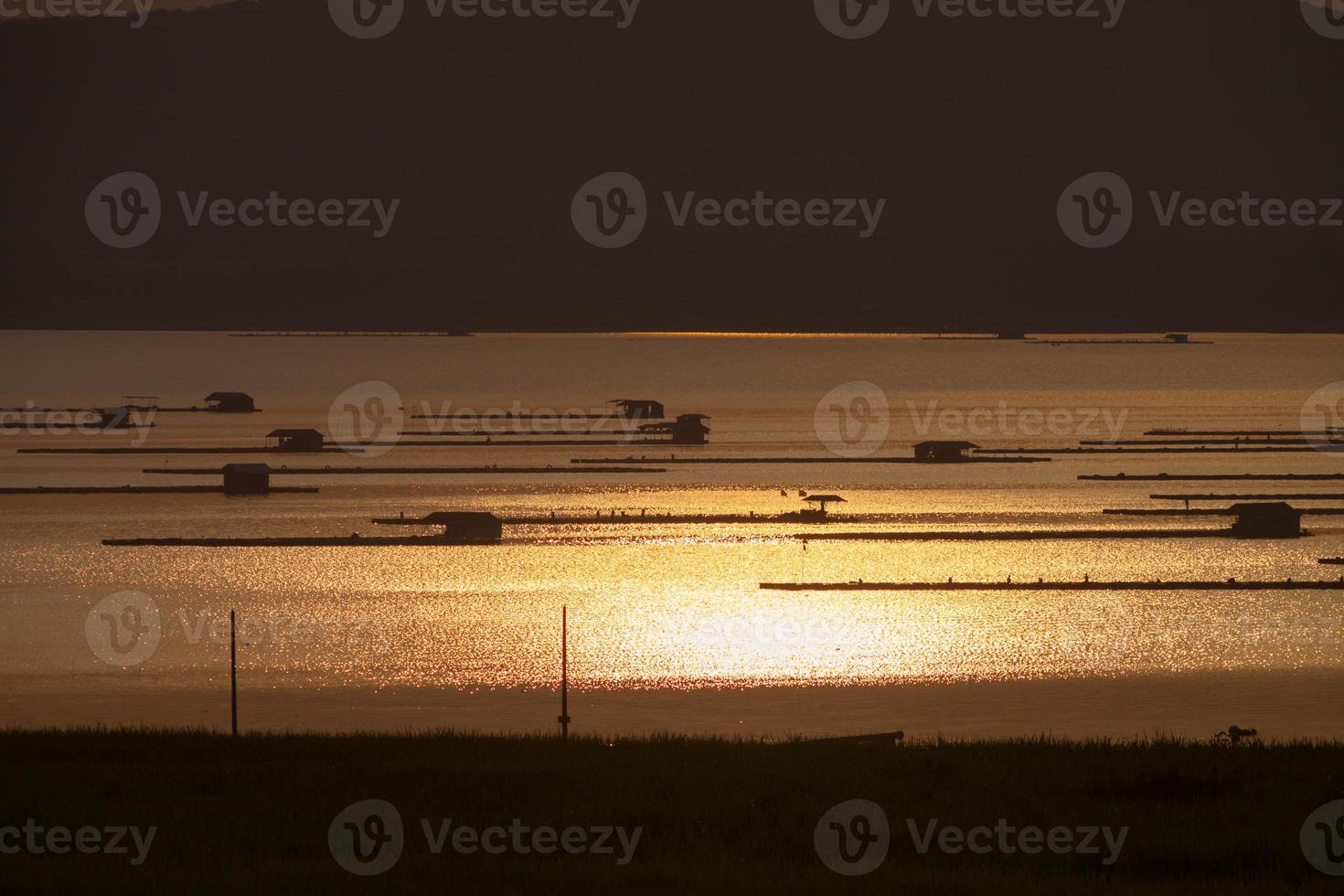 cabanas flutuantes na água ao pôr do sol foto