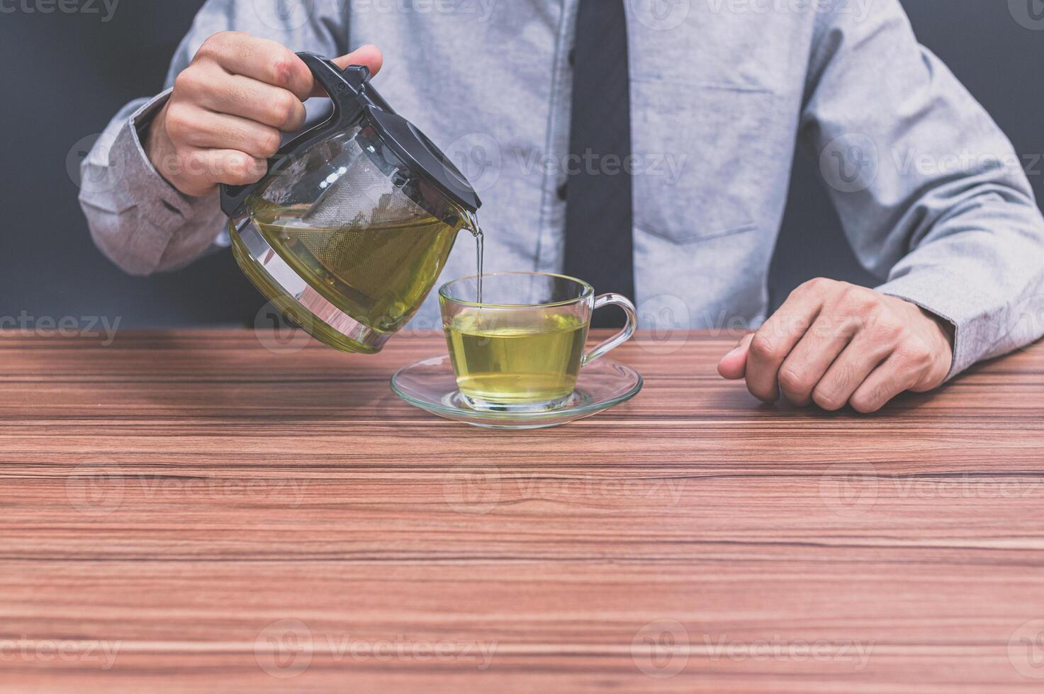 um homem servindo uma xícara de chá foto