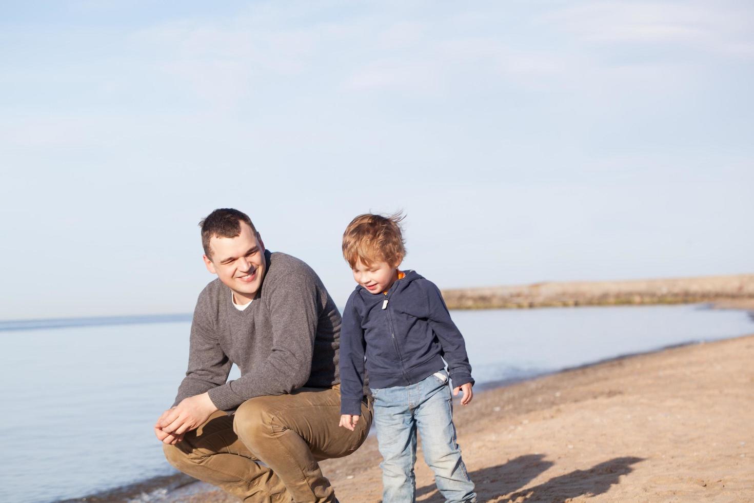 pai com seu filho na praia foto