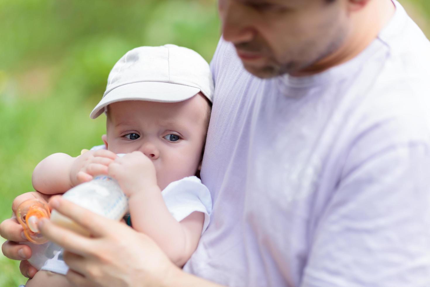 pai alimentando seu bebê na mamadeira foto