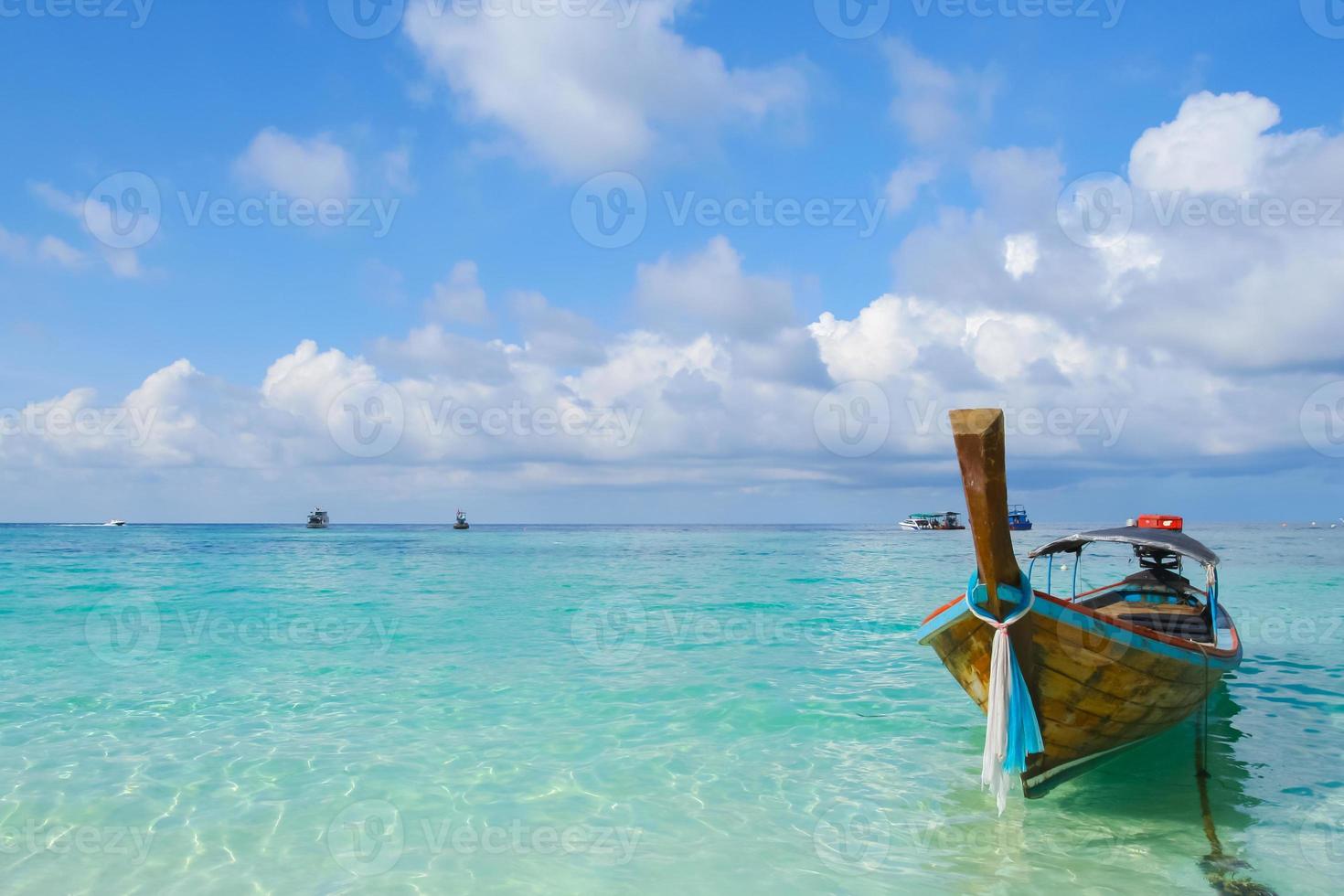 barco longo flutuando em praia tropical foto