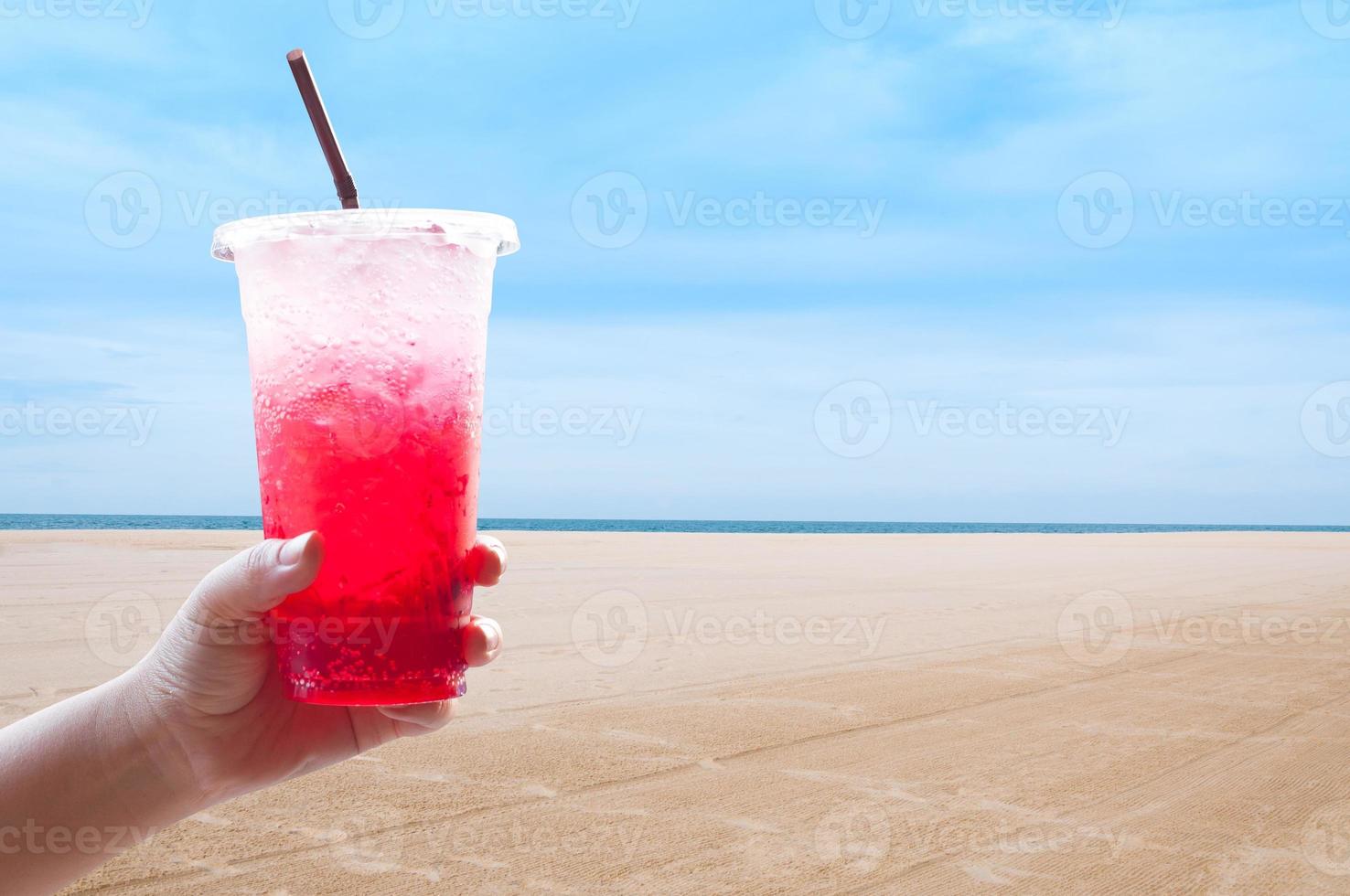 mulheres lidar com segurando gelo água italiano refrigerante vermelho dentro plástico copo, vermelho, doce legal beber dentro a verão às a praia, durante a feriados foto