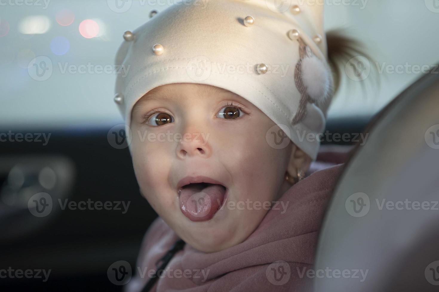 pequeno menina mostra dela língua. engraçado crianças. foto