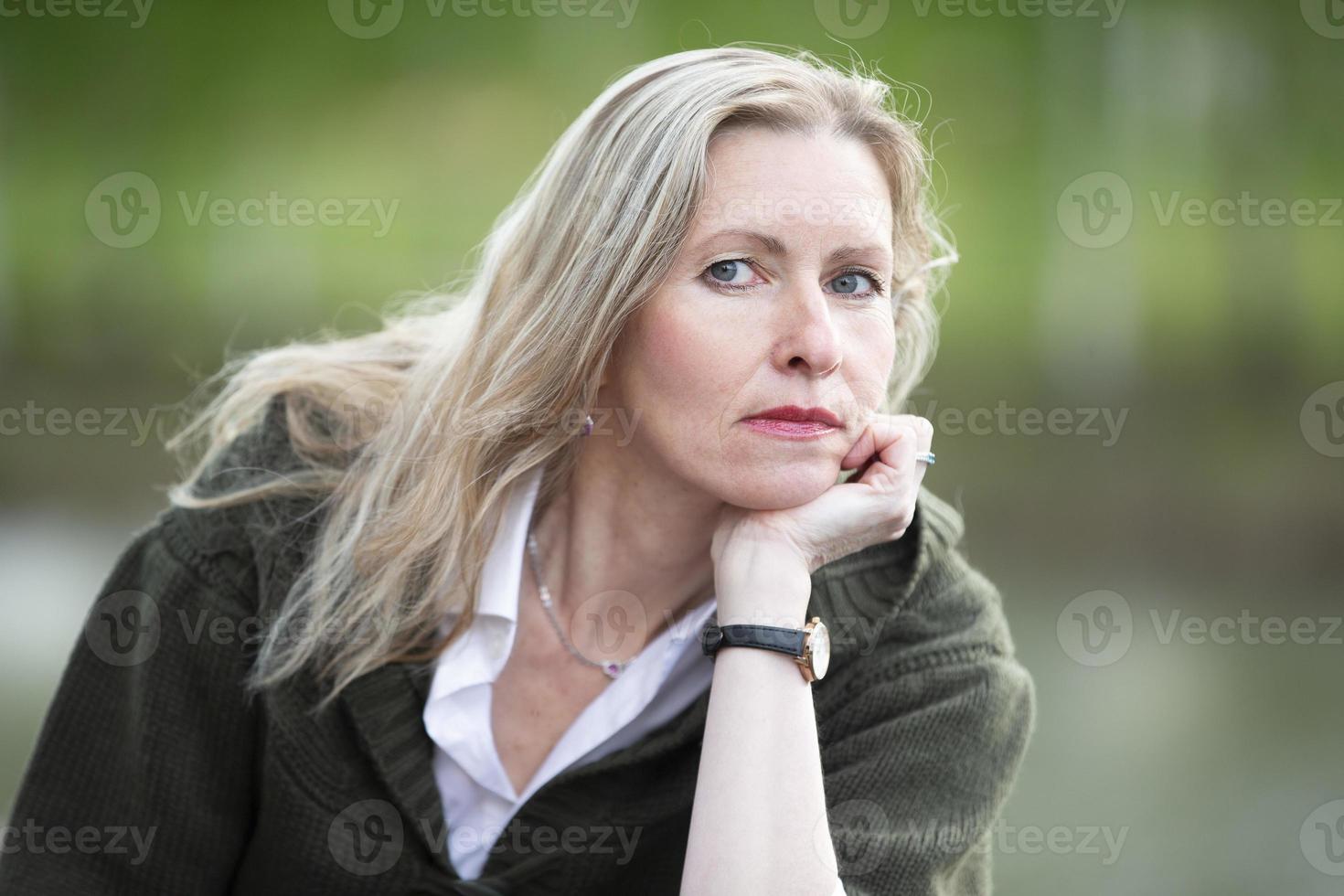 retrato de uma bela loira idosa de aparência europeia. close-up de mulher de cinquenta anos em um fundo natural foto