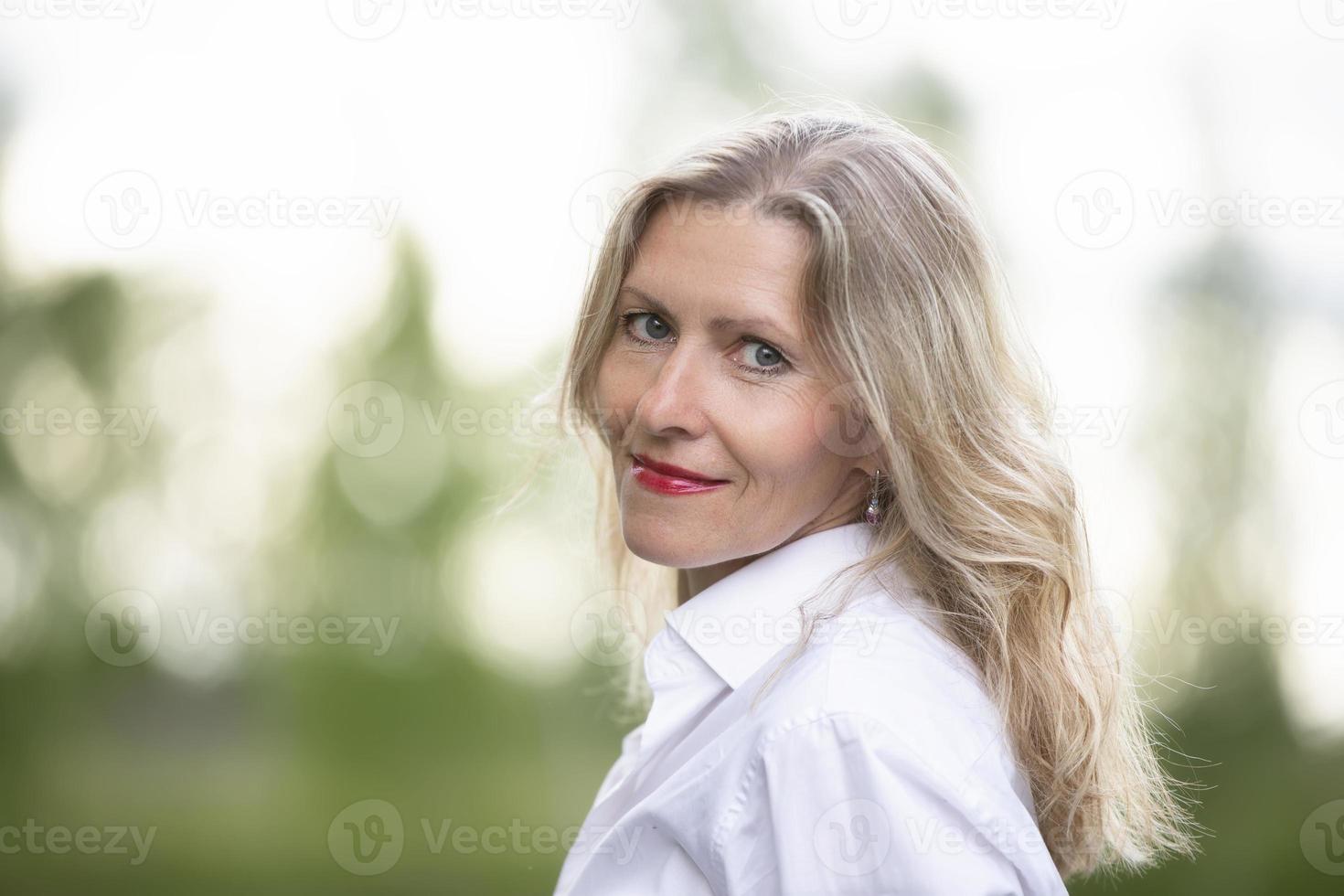 retrato do uma lindo europeu meia idade mulher. cinquenta anos Loiras mulher com uma bem cuidado face fechar-se. foto