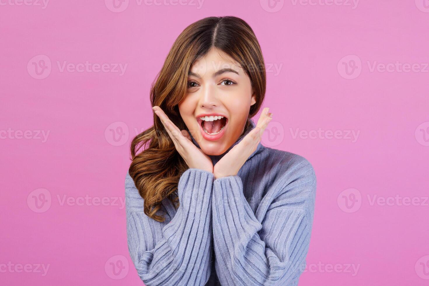 retrato de jovem animado sorridente com as mãos sob o queixo isolado sobre fundo rosa foto