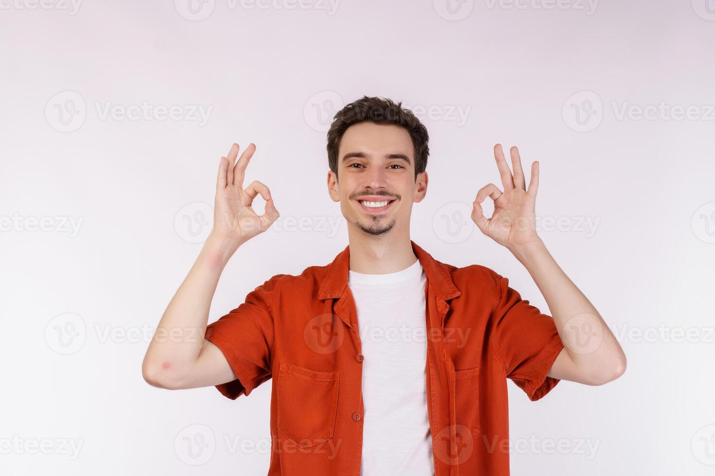 retrato do feliz jovem bonito homem fazendo Está bem placa com mão e dedos sobre branco fundo foto