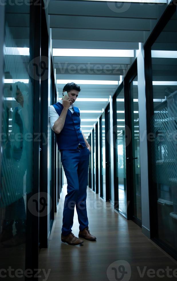 o negócio homem dentro a corredor do a conferência sala, falando para a assistente em a telefone para perguntar para alguns detalhes. foto