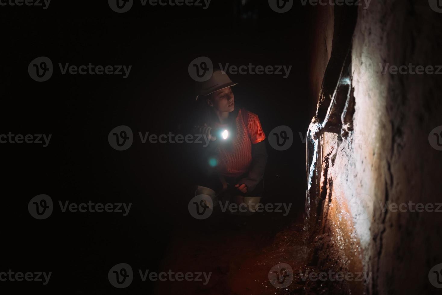 escavadora feminina com lanterna explora o túnel foto