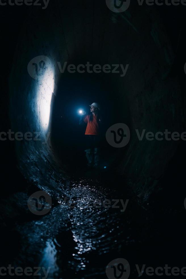 escavadora feminina com lanterna explora o túnel foto