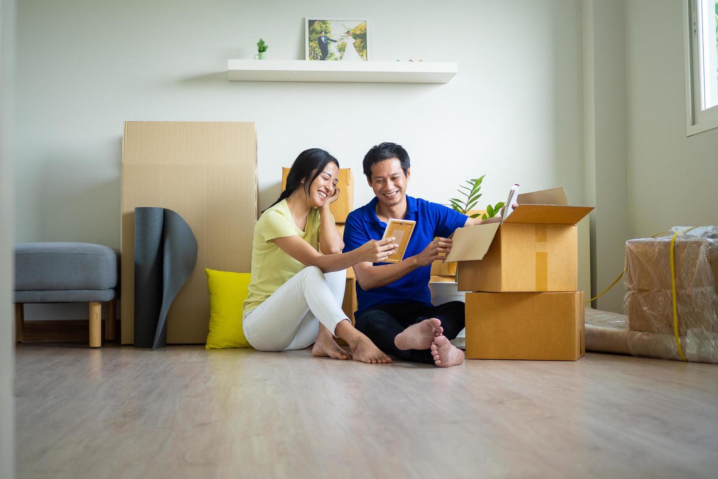 uples sentado e conversando alegremente depois de comovente Itens para dentro a Novo casa. casa comovente Ideias foto