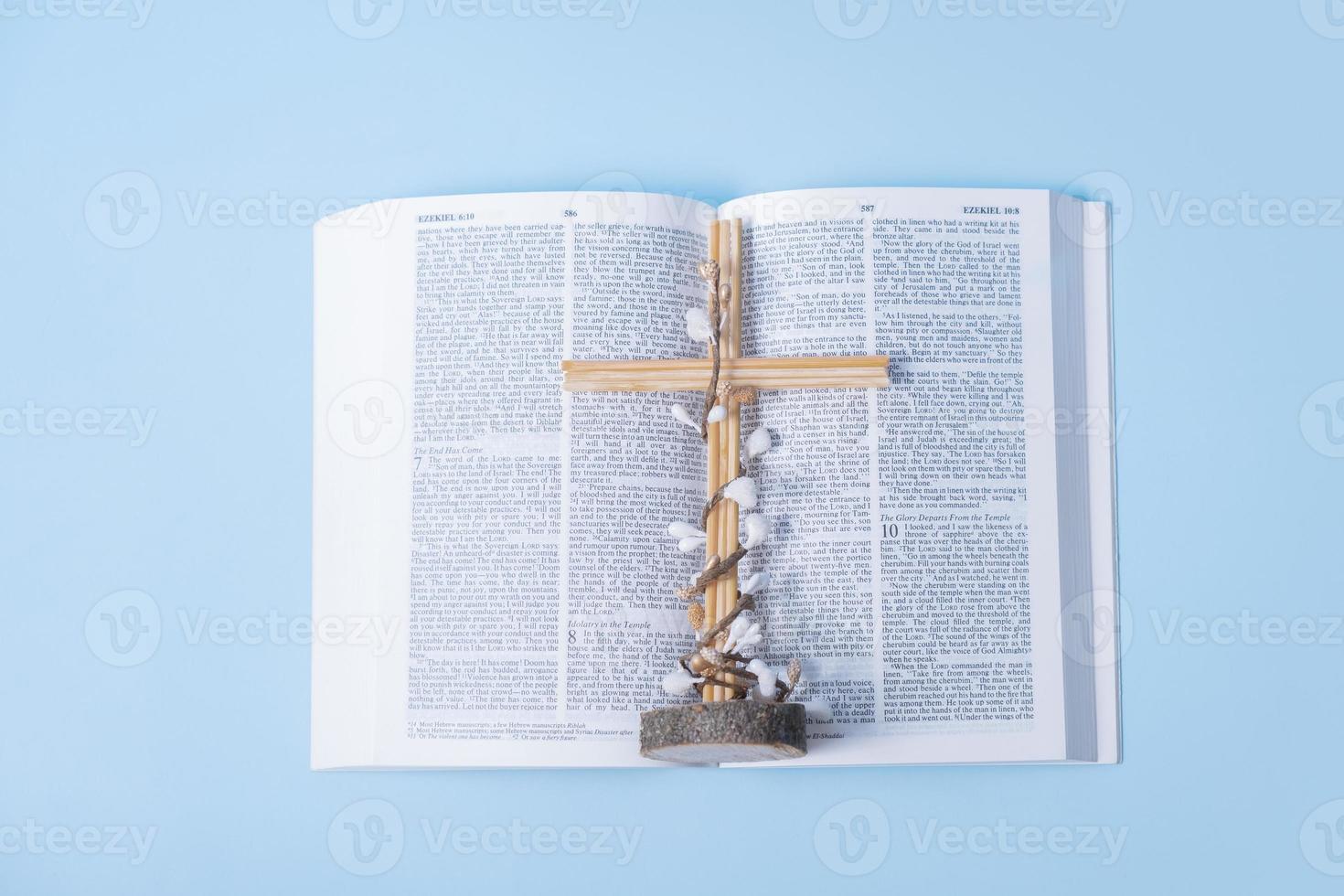 aberto piedosos Bíblia com Cruz e decorativo flores em azul fundo foto