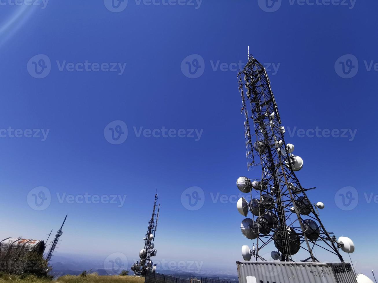 torre de antena de comunicação celular de telecomunicações em fundo azul foto